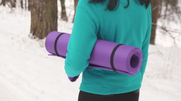 Ragazza con un tappetino yoga per l'inverno lenta mo — Video Stock