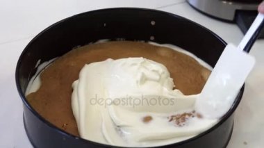 Beyaz krema bir yuvarlak kek üzerine koyarak el