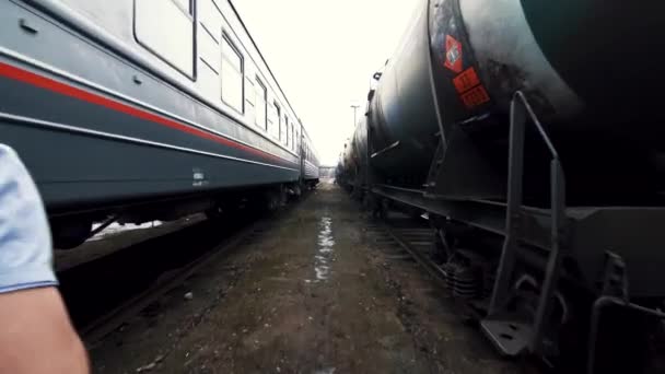 El hombre corre sobre el fondo de dos trenes — Vídeo de stock