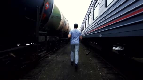 Male athlete boxer runs among the trains — Stock Video