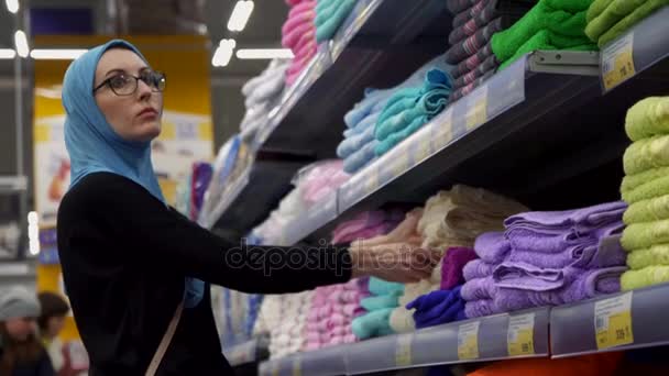 Aantrekkelijke moslim meisje winkelen, kies stoffen, kleding — Stockvideo