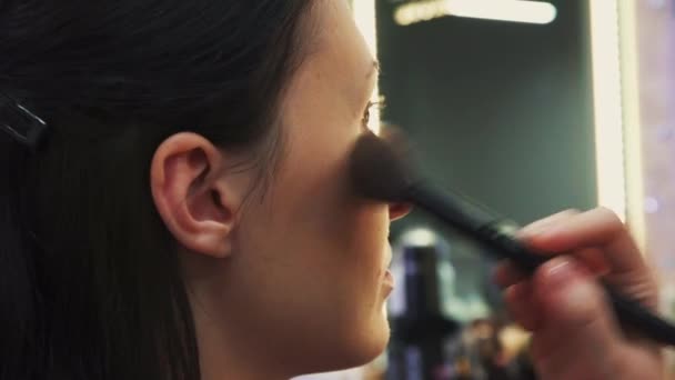 Proces van het maken van de make-up, Make-up kunstenaar werken met borstel op model gezicht — Stockvideo