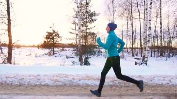 Спортивна мусульманська дівчина на бігу взимку, повільний мо, сонце — стокове відео