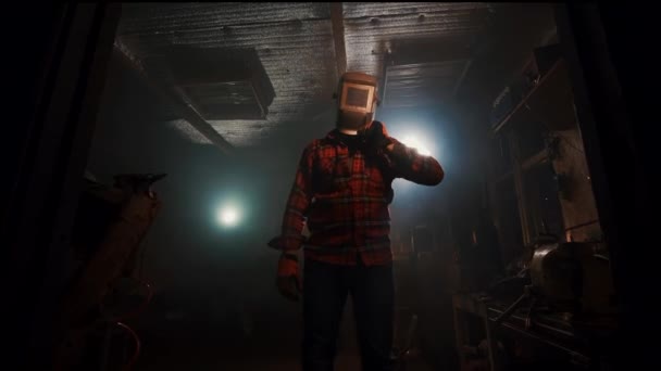 Retrato de un hombre con brazos cruzados en la máscara de soldadura en el garaje de la casa — Vídeos de Stock