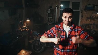raflar garaja araçlarıyla arka plan üzerinde başparmak gömlekli erkek makinist ortaya