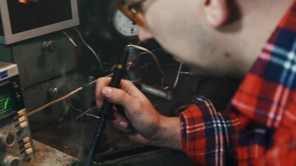 Мужчина в собственном гараже занимается пайкой крупным планом — стоковое видео