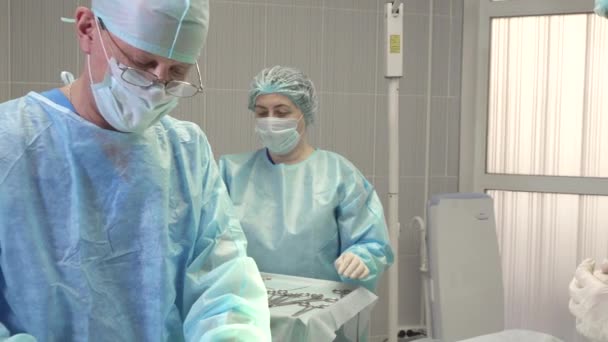 L'infirmière assiste le chirurgien et passe le scalpel et les ciseaux pendant l'opération — Video