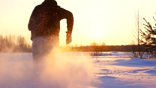 Siluett man kör genom snön i vinterlandskap — Stockvideo