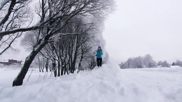 Fille épique court le long de la neige profonde en hiver dans le parc — Video