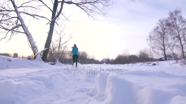 Mädchen im Winterpark läuft bei Sonnenuntergang — Stockvideo