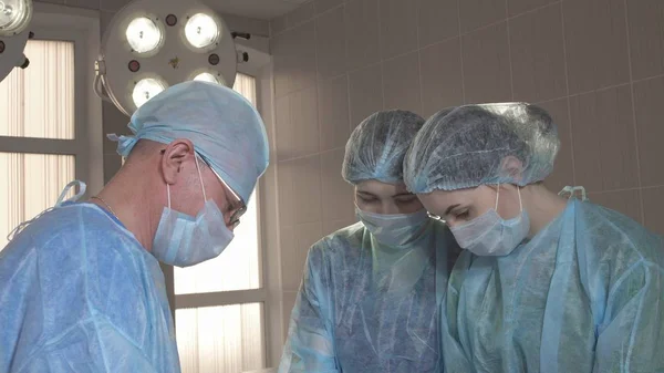 cerrah hastane odasında bir operasyon sırasında hemşireler için açıklar