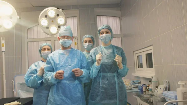 üç hemşire ve bir cerrahı ameliyathanede işlemi tamamlandıktan sonra