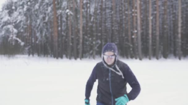 Un hombre congelado camina por el bosque de invierno, después de una tormenta de nieve, cubierto de nieve sonriendo — Vídeos de Stock