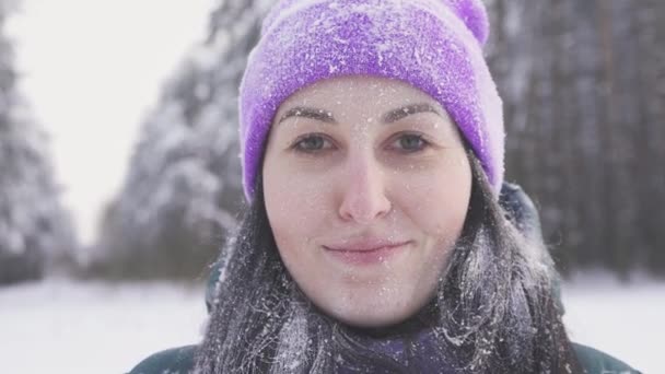 孤独的女孩在树林里微笑着看着摄影机, 雪后覆盖着雪 — 图库视频影像