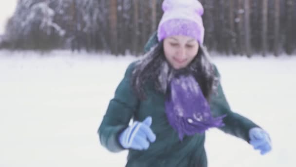 Chica en el bosque de invierno después de una tormenta de nieve corre hasta la cámara cubierta de nieve — Vídeos de Stock