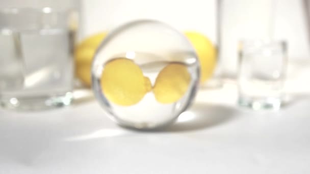 Reflexão em uma bola de vidro dois amarelo limão fresco no fundo branco — Vídeo de Stock