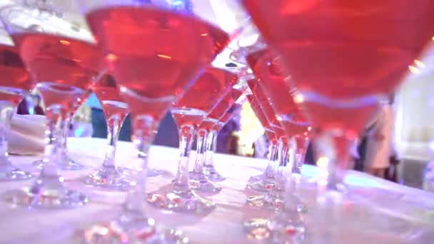 Glasses with alcohol on the background of dancing people at a party — Stock Video