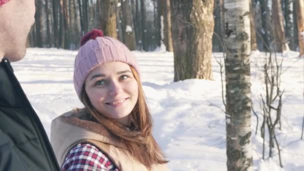 Een aantrekkelijk meisje loopt samen met een jongen in het bos van de winter — Stockvideo