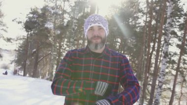 Kollarını geçerken bir kış ormandaki sakallı bir gülümseyen adam portresi