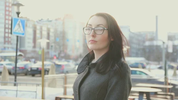 Attractive girl with glasses and coat in the background of the cityscape Royalty Free Stock Images