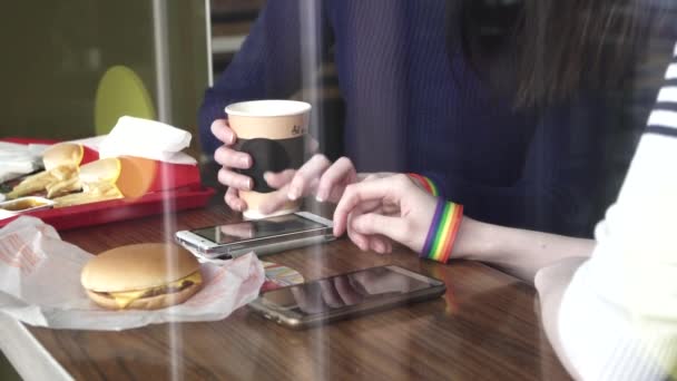 Dámské ruce v kavárně pomocí telefonu s Lgbt náramky — Stock video