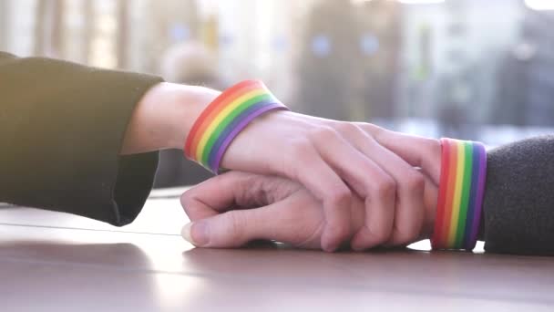 通りに、テーブルの背景に Lgbt のブレスレットのために達する 1 つの手 — ストック動画