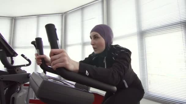 Atleta donna in hijab sportivo sul simulatore di bici — Video Stock