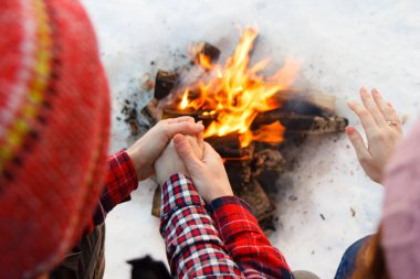 onlar ateşin yanında ellerini sıcak