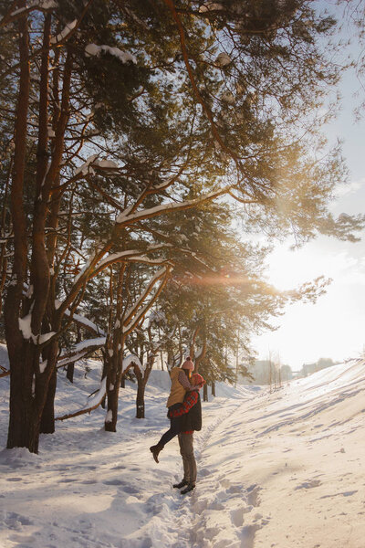 couple in love in the winter sunny forest