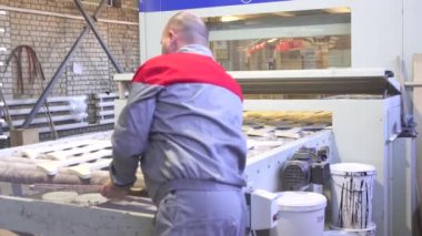 adam otomatik boyama hattı üzerinde çalışıyor