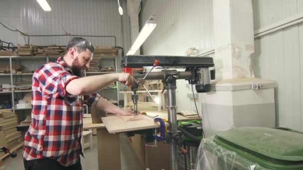Человек плотник в рубашке с помощью буровой машины в мастерской — стоковое видео
