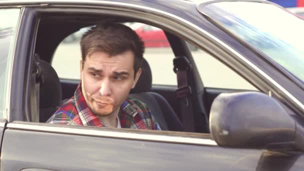 Bir tişörtlü adam bir araba alkol içecekler — Stok video