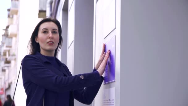 Aveugle fille dans la rue lecture braille sur une plaque d'information sur le bâtiment — Video