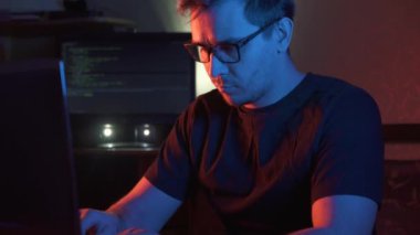 Kameraya bakarak bir adam karanlık bir odada bardaklarda bilgisayar