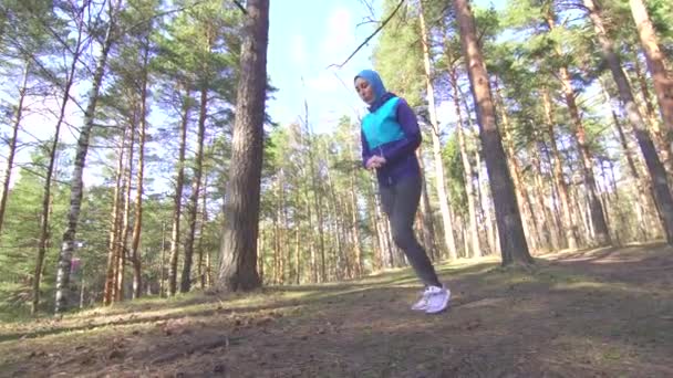 Meisje in hijab doen die zich uitstrekt in de ochtend in zonnig bos — Stockvideo
