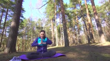 pratik Yoga bir güneşli ormanda kız