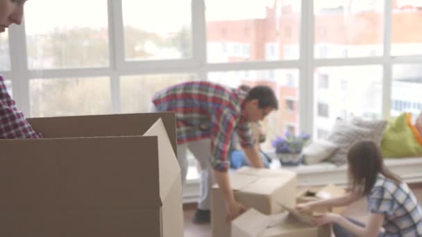 Familia feliz desempaca cajas de cosas — Vídeos de Stock