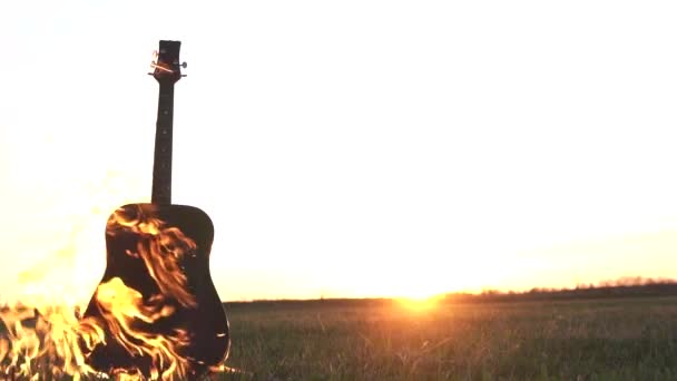 Палаюча гітара під вогнем у полі — стокове відео