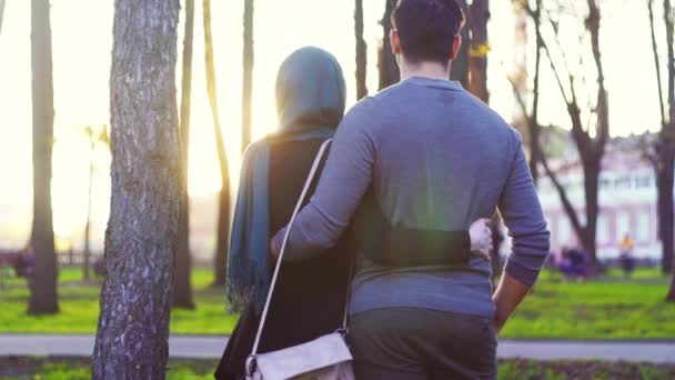 Mann und Frau im Hidschab umarmen sich im Park — Stockvideo