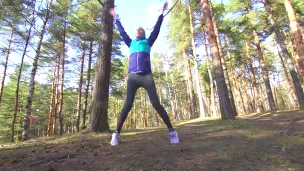 日当たりの良い林の朝のウォーム アップを行うヒジャーブの女の子 — ストック動画