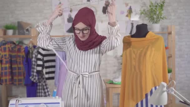 Portrait of a young muslim woman fashion designer in National headscarf with a measuring tape — Stock Video