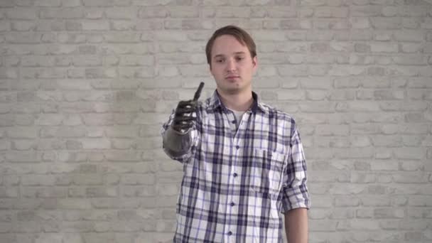 Positive young man shows thumbs up bionic prosthetic hand — Stock Video