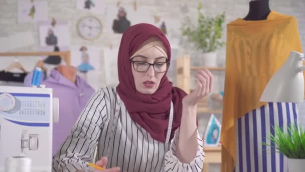 Junge muslimische Modedesignerin mit nationalem Kopftuch hat Schwierigkeiten mit Ideen, keine Inspiration — Stockvideo