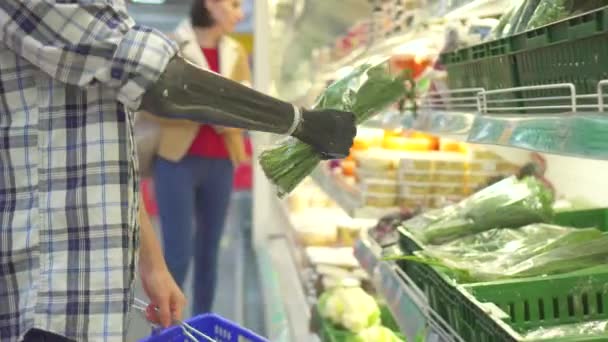 Young man with a cyber prosthetic hand in a hypermarket — ストック動画