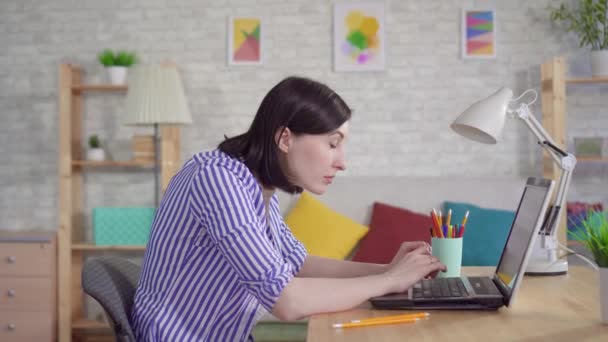 Молода жінка, що працює на ноутбуці, відчуває біль в очах — стокове відео