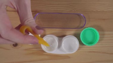 Göze merceği yerleştirir ve lensi kullanır.