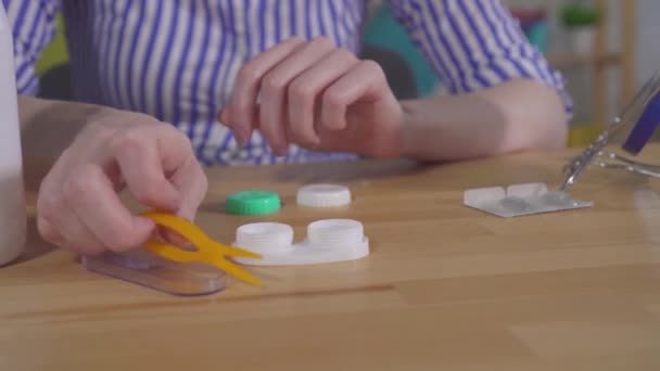 Young womans hands take contact lenses out of the container — Stock Video