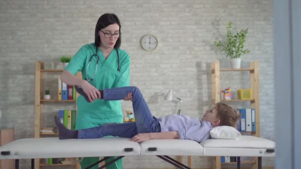 Маленький мальчик на приеме у физиотерапевта — стоковое видео