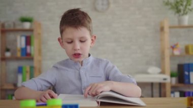 Anaokulu çocuğu kitap okuyor.