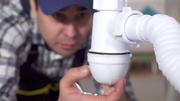 Plumber repairs a leak under the sink slow mo — Stock Video